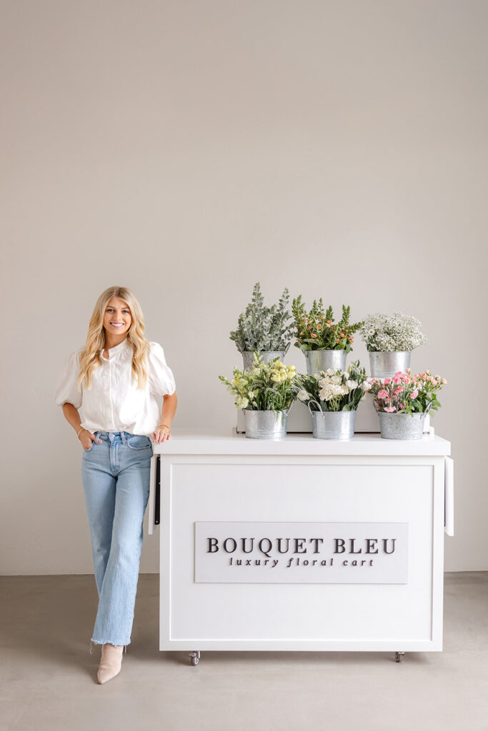 Sacramento brand photography session of a woman standing next to a white counter with flowers