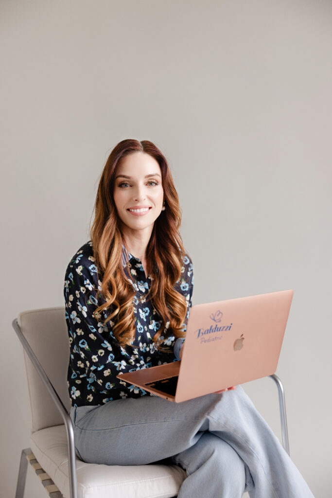 a woman sitting in a chair with a laptop