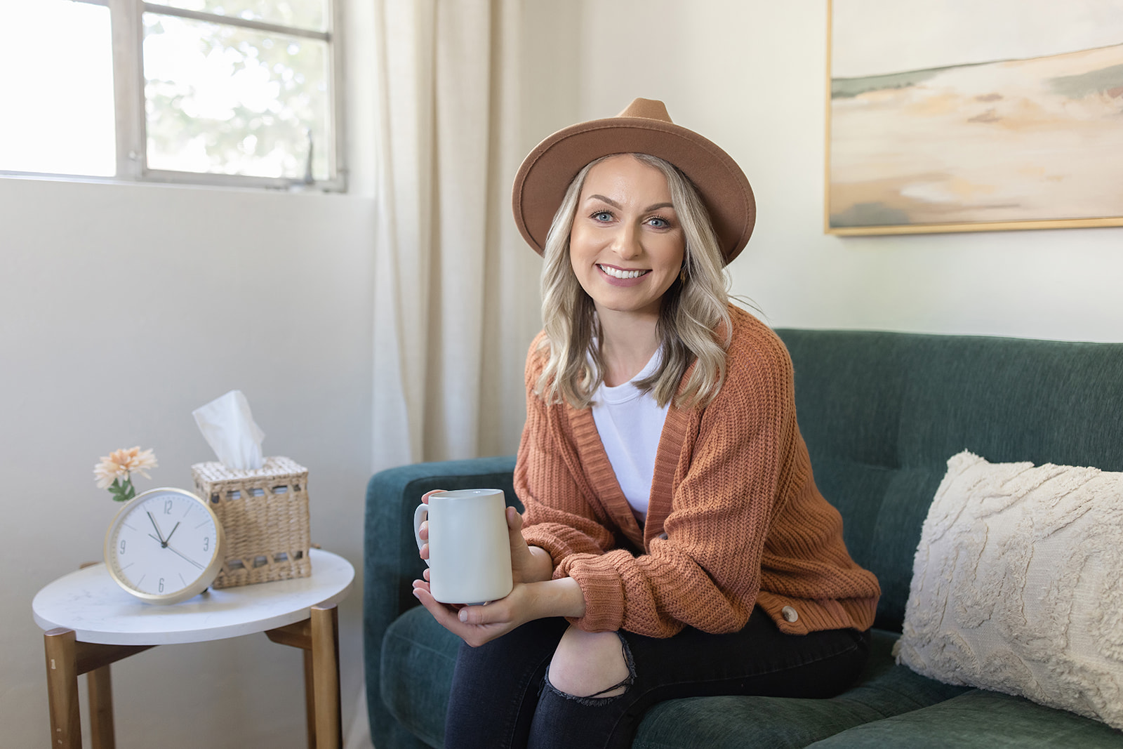 a therapist sitting on a couch holding a mug