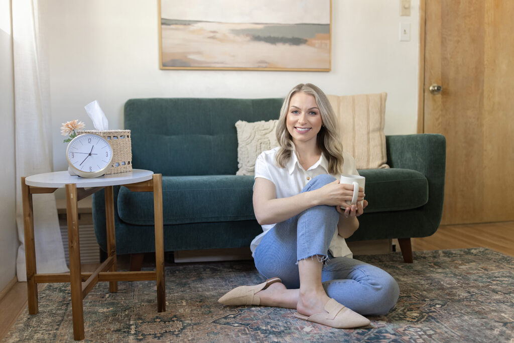 a woman sitting on the floor holding a cup