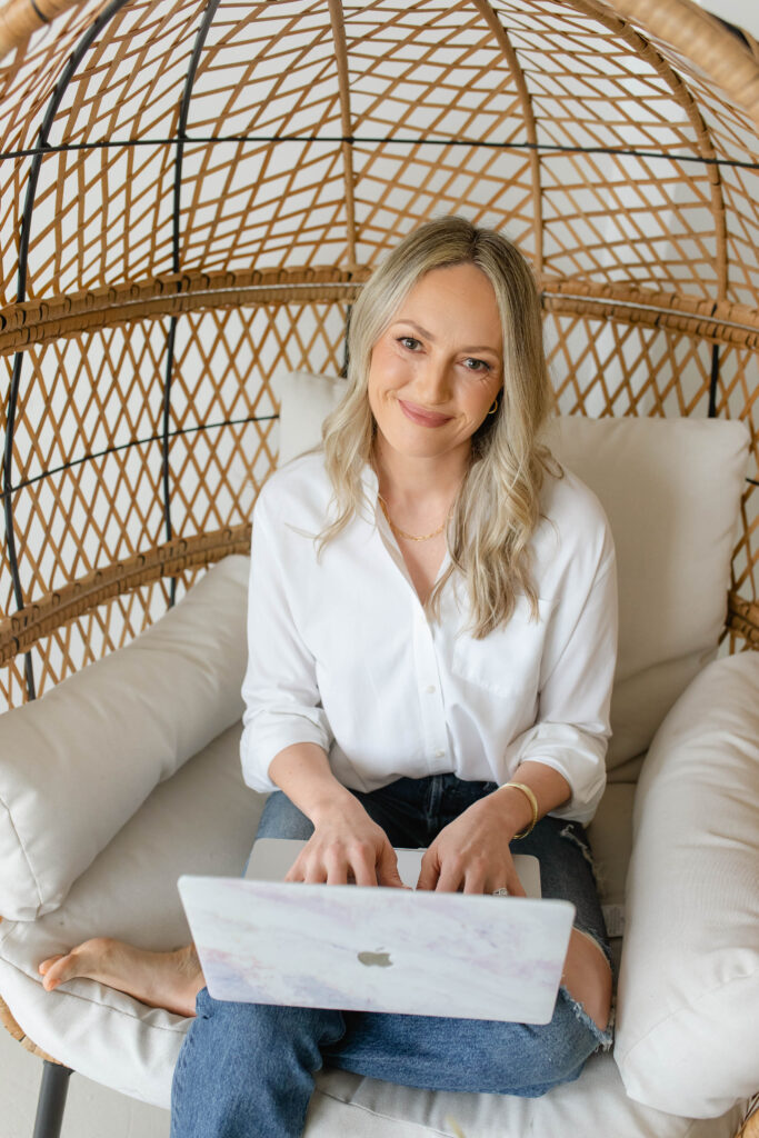 a woman sitting at a desk with a laptop and a book