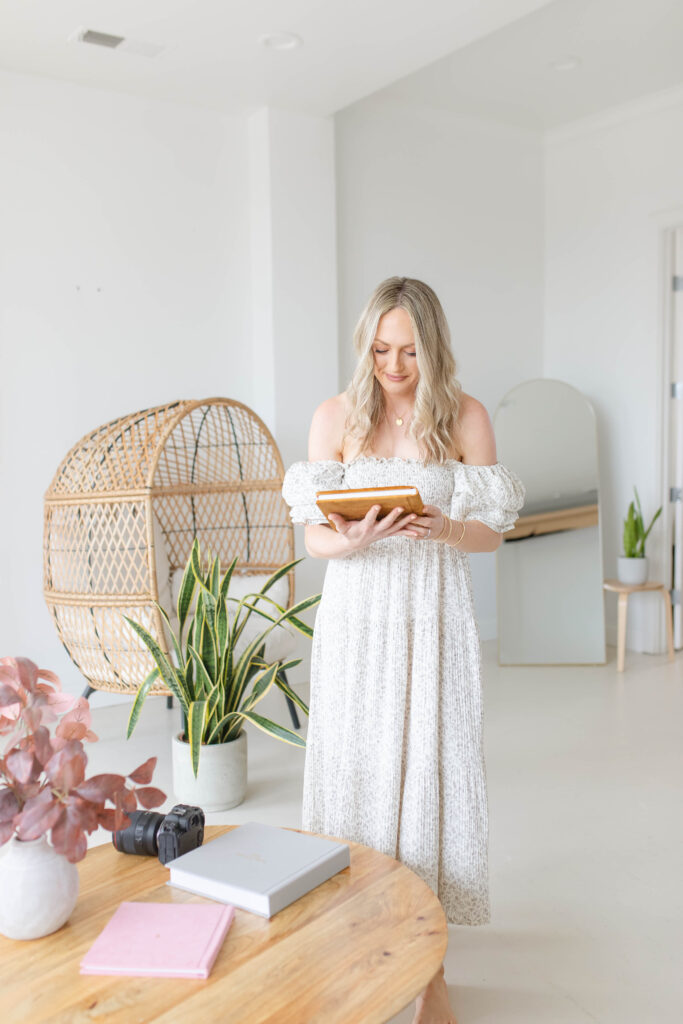 a woman in a white dress holding a tablet