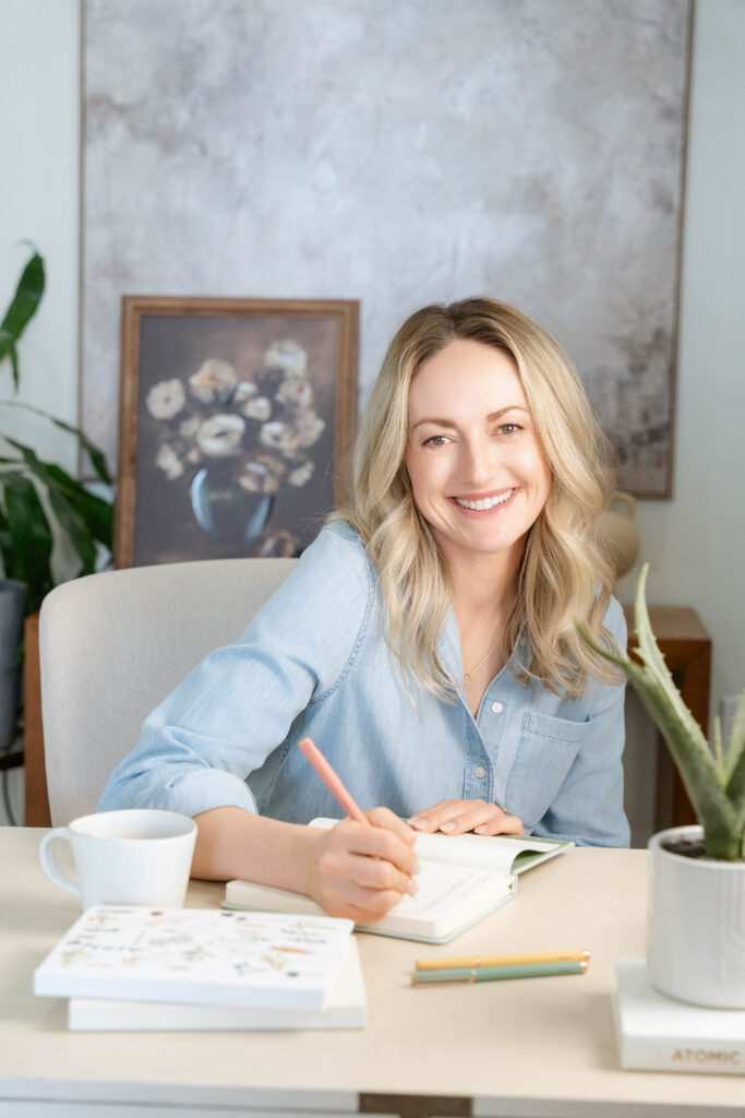 Professional headshot of Sacramento branding photographer Nicole Hodgson smiling with camera.