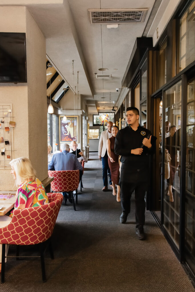 A cozy and welcoming view of the restaurant's dining space filled with happy guests.