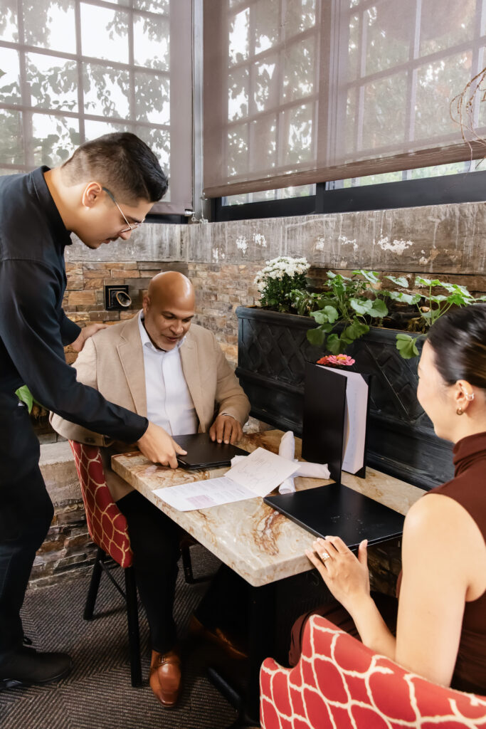 A cozy and welcoming view of the restaurant's dining space filled with happy guests.