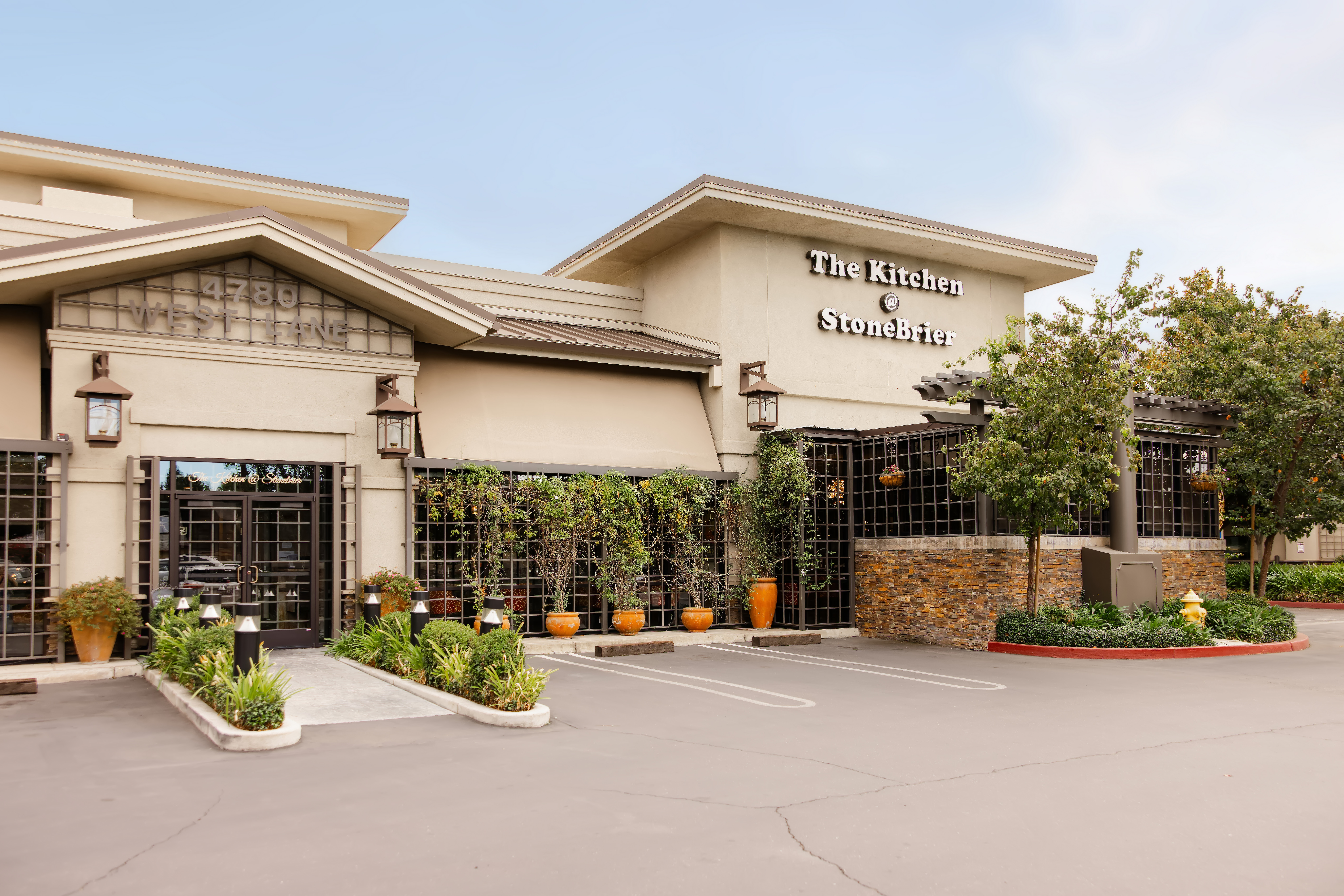 Exterior view of The Kitchen at StoneBrier restaurant with warm lighting at dusk