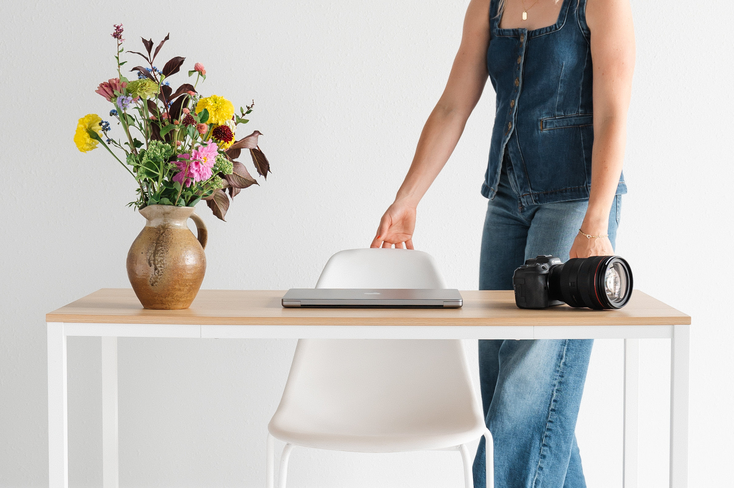 Person arranging a workspace with flowers.